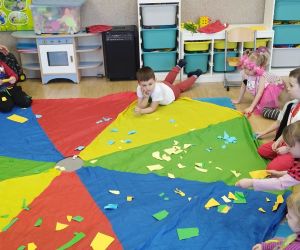 Przedszkolaki z wychowawczynią podczas zabaw z chustą animacyjną