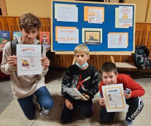 Chłopcy trzymają dyplomy, które otrzymali z okazji dnia chłopaka.