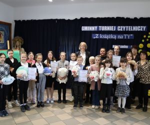 Na zdjęciu widoczna jest grupa dzieci wraz z dorosłymi pozująca do wspólnego zdjęcia.