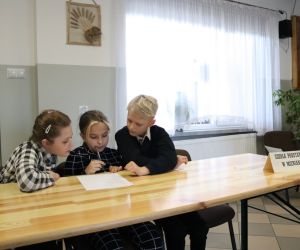 Na zdjęciu widoczne są dzieci rozwiązujące zadania.