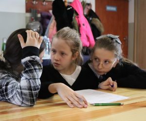 Na zdjęciu widoczne są dzieci rozwiązujące zadania.