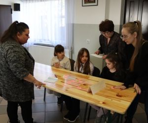 Na zdjęciu widoczna jest trzyosobowa drużyna oraz komisja sprawdzająca rozwiązane zadania.