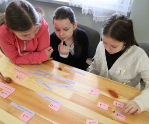 Na zdjęciu widoczne są dzieci rozwiązujące zadania konkursowe.