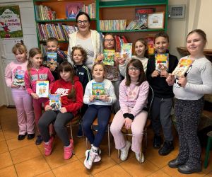 Na zdjęciu widoczna jest grupa dzieci wraz z nauczycielem.