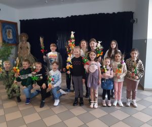 Na zdjęciu widoczna jest grupa dzieci prezentująca swoje palmy wielkanocne.