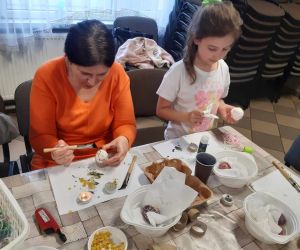 Na zdjęciu widoczne są dzieci i dorośli podczas warsztatów wielkanocnych.