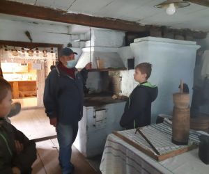 Przewodnik w jednej z izb opowiada uczniom o życiu w dawnych czasach