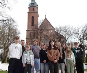 Uczniowie na tle kościoła w Trzeszczanach
