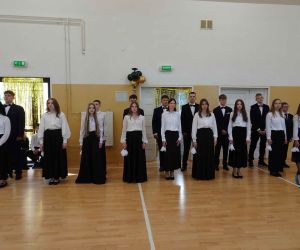 Uczniowie stoją przy ścianie w oczekiwaniu na taniec Poloneza