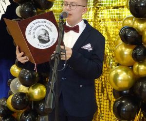 Uczeń klasy VIII czyta swoja kwestię przed mikrofonem