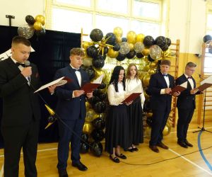 Uczniowie klasy VIII czytają swoje kwestie przed mikrofonem