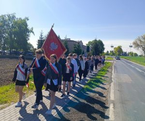 Uroczysty przemarsz uczniów na mszę z okazji Dnia Patrona z pocztem sztandarowym na czele