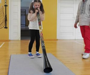 Uczennica próbuje zagrać na instrumencie dętym