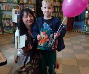 Zdjęcie przedstawia dziecko pozujące wraz z opiekunem.