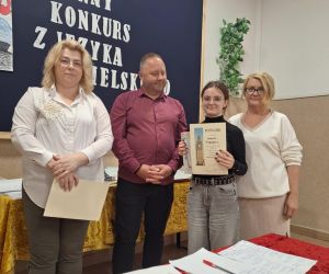 Uczennica klasy VII prezentuje dyplom i nagrodę