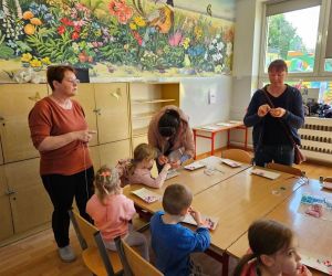 Panie z KGW tłumacza dzieciom jak wykonywać bransoletki z koralików