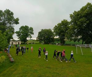 Uczniowie i nauczyciele podczas okrążania boiska