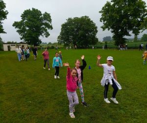 Uczniowie klas młodszych podczas okrążania boiska