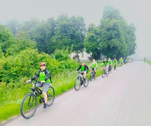 Uczniowie w kamizelkach odblaskowych jadą na rowerach