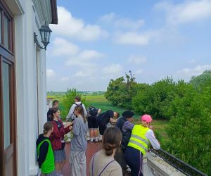 Uczniowie i nauczycielka na pałacowym balkonie