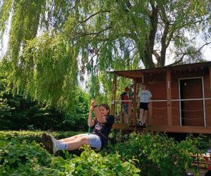 Uczennica zjeżdża tyrolką z drewnianego domku