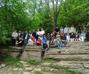Uczestnicy wycieczki siedzą na skale pod nazwą Księgi
