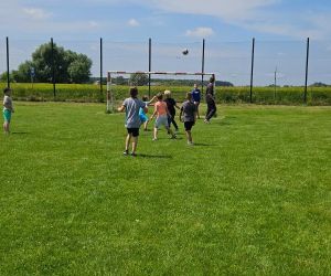 Uczniowie grają w piłkę na boisku szkolnym 