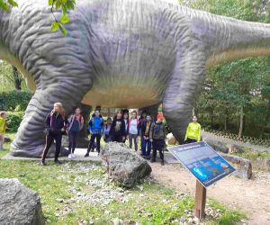 Grupa uczniów pod brzuchem dinozaura