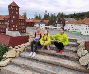 Trzy uczennice na schodach w parku miniatur