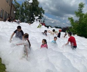 Uczniowie podczas zabawy w pianie na boisku szkolnym