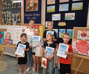 Nauczycielka oraz uczniowie trzymający dyplomy