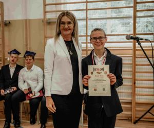 Dyrektor szkoły stoi obok zwycięzcy w turnieju szachowym