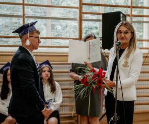 Dyrektor szkoły wręcza ósmoklasiście świadectwo z wyróżnieniem