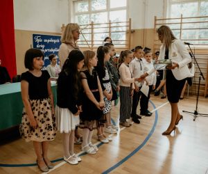 Dyrektor szkoły wręcza nagrodę uczniom klasy trzeciej za wygraną w konkursie 