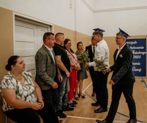 Ósmoklasiści wręczają kwiaty swoim rodzicom