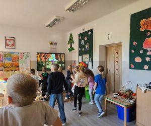 Uczniowie klas młodszych biorą udział w zabawie ruchowej przed ekranem, na którym wyświetlana jest animacja.