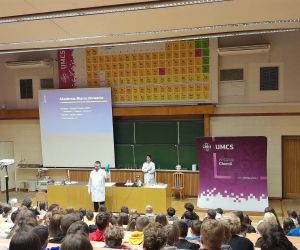 Dwoje wykładowców rozpoczyna pokazy dla uczniów siedzących w auli