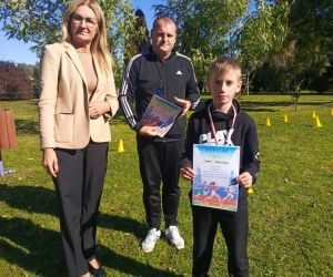 Dyrektor szkoły, nauczyciel wychowania fizycznego i uczeń klasy czwartej, zdobywca trzeciego miejsca