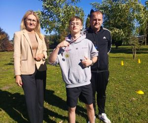 Dyrektor szkoły, nauczyciel wychowania fizycznego i uczeń klasy ósmej, zdobywca pierwszego miejsca