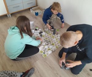 Troje uczniów gra w grę logiczną Gravitrax