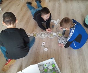Trzech uczniów układa trasę w grze planszowej Gravitrax