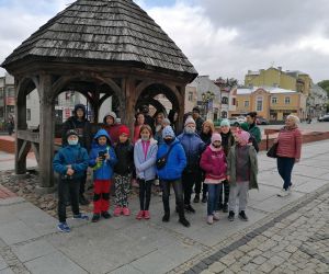 Grupa uczniów przy studni miejskiej na deptaku w Chemie.