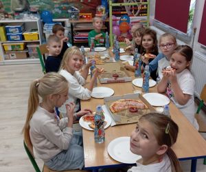 Uczniowie jedzą pizzę