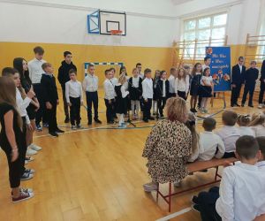 Uczniowie stoją półkolem przed widownią