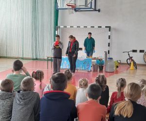 Uczeń trzyma czerwony balonik-zabawy z helem