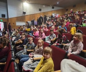 Uczniowie siedzą na widowni w Hrubieszowskim Domu Kultury, czekając na rozpoczęcie spektaklu muzycznego.