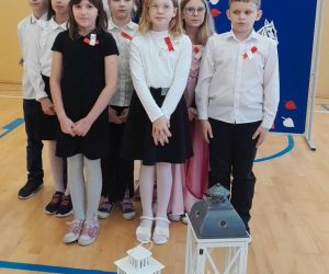 Uczniowie klasy czwartej uczestniczący w apelu, wraz z wychowawczynią