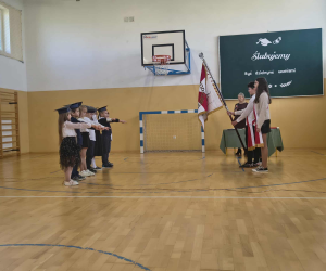 Uczniowie składają ślubowanie w kierunku pocztu sztandarowego.