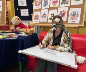 uczennica maluje misia z zasłoniętymi oczami