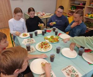 . Uczniowie klasy VI wspólnie omawiają przygotowane posiłki i przygotowują się do degustacji.